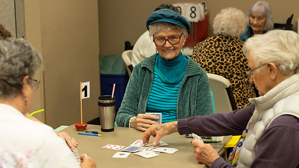 Elderly woman playing cards with friends